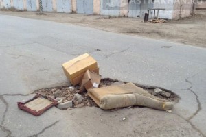 Астраханцы закидали мусором опасную яму на дороге