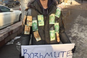 В Алматы по центру ходит молодой человек, обклеенный деньгами